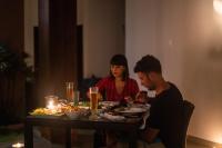 a man and a woman sitting at a table with food at The Habitat Kosgoda by Asia Leisure in Bentota