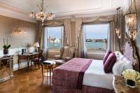 a hotel room with a bed and a desk and window at Baglioni Hotel Luna - The Leading Hotels of the World in Venice