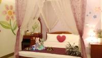a bedroom with a bed with a canopy with a stuffed animal at sweet home B&amp;B in Hualien City