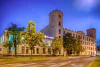 Un edificio con una torre de reloj en la parte superior. en Focus Hotel Łódź, en Łódź