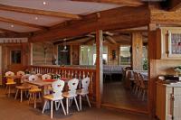 a restaurant with tables and chairs and a bar at Apartments Pitschlmann in Fiè
