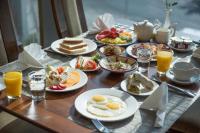 a table topped with plates of breakfast foods and orange juice at Kuwait Grand Hotel in Kuwait