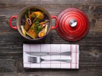 Een pan met eten op tafel, met een vork en een mes erbij. bij Hôtel Alpen Ruitor in Méribel