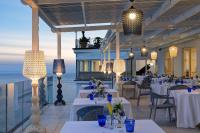 a restaurant with white tables and chairs and lights at Lloyd's Baia Hotel in Vietri sul Mare