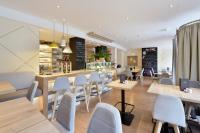a restaurant with white chairs and tables and a counter at Am Neutor Hotel Salzburg Zentrum in Salzburg
