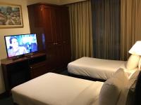 ein Hotelzimmer mit zwei Betten und einem Flachbildfernseher in der Unterkunft KL Service Suites at Times Square KL in Kuala Lumpur