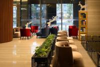 a lobby with chairs and tables and deer statues at Golden Tulip Glory Fine Hotel in Tainan