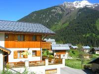 a building with wooden balconies and a mountain at A detached chalet for 6 people with views of Veysonnaz in Le Villard