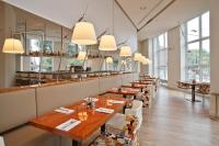 una fila de mesas en un restaurante con ventanas en Park Centraal Amsterdam, part of Sircle Collection, en Ámsterdam