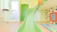 a childs bedroom with a green slide up the wall at Minsuku B&amp;B in Taitung City