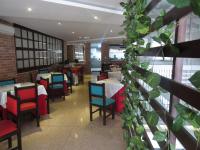 a dining room with tables and chairs and plants at Hotel León Dorado in Bucaramanga