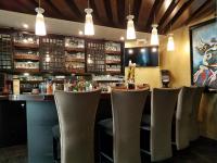 a bar in a restaurant with chairs and lights at Isabella Boutique Hotel in San Pedro Sula