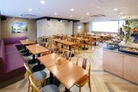 a restaurant with wooden tables and chairs and a counter at Day Nice Hotel Tokyo in Tokyo
