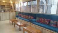 a blue couch in a library with pillows and tables at Baba Guest House in Varanasi