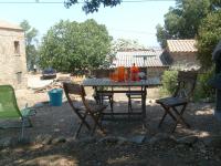 a picnic table and two chairs in a yard at Gîte à Piscia de Figari Petru Barbara in Figari