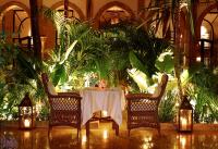 a table with a white table cloth and chairs and plants at Heure Bleue Palais - Relais & Châteaux in Essaouira