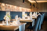 a row of tables with white napkins and flowers on them at Hotel Mareo Dolomites in San Vigilio Di Marebbe