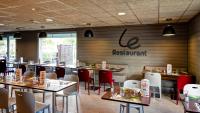 een restaurant met tafels en stoelen en een bord aan de muur bij Campanile Evry Ouest - Corbeil Essonnes in Corbeil-Essonnes