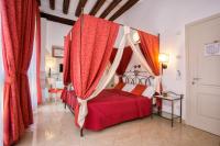 a bedroom with a red bed with a canopy at Alla Vite Dorata in Venice