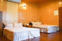 two beds in a room with wooden walls at Taroko Sialin Coffee Farm Homestay in Xiulin