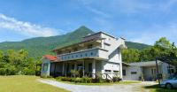 a white house with a mountain in the background at Taroko Sialin Coffee Farm Homestay in Xiulin