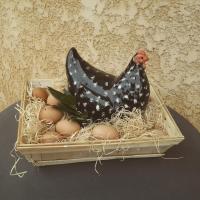 a chicken sitting in a basket of eggs at Les Hotes Des Guillemets in Laglorieuse