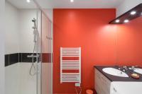 a bathroom with a red wall with a sink and a shower at Le Ponant by Cocoonr in Dinard