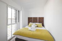 a bedroom with a bed with yellow sheets and a window at Le Ponant by Cocoonr in Dinard