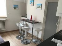 a small table with four stools in a room at Lumineux T2 Vieille ville 3 pers parking gratuit - by La Source d&#39;OrFée in Boulogne-sur-Mer