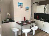 a small kitchen with a table and four stools at Lumineux T2 Vieille ville 3 pers parking gratuit - by La Source d&#39;OrFée in Boulogne-sur-Mer