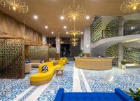 a lobby of a hotel with blue and yellow furniture at Eastin Ashta Resort Canggu in Canggu
