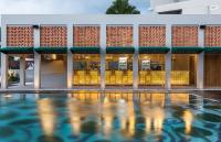 a hotel with a swimming pool in front of a building at Eastin Ashta Resort Canggu in Canggu