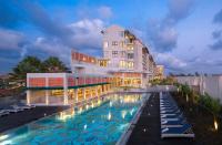 a hotel with a swimming pool in front of a building at Eastin Ashta Resort Canggu in Canggu