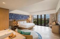 a bedroom with a bed and a bathroom with a tub at Eastin Ashta Resort Canggu in Canggu
