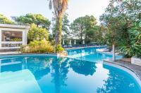a swimming pool with blue water and trees at Kilina in Porto-Vecchio