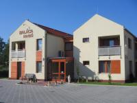Un edificio blanco con un cartel al costado. en Baláca Panzió, en Veszprém