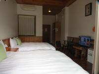 a hotel room with a bed and a television at Seasons Inn in Jiaoxi