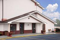 a large white building with a parking lot at Hillside Inn &amp; Suite in Martinsburg