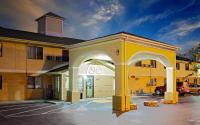 un edificio amarillo con un arco en un aparcamiento en Super 8 by Wyndham Muncie&#47;Ball St. College Area, en Muncie