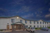Un edificio con un coche aparcado en un estacionamiento. en Delavan Inn and Suites, en Delavan
