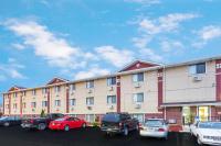un gran edificio de apartamentos con coches aparcados en un aparcamiento en Super 8 by Wyndham Kenosha&#47;Pleasant Prairie, en Pleasant Prairie