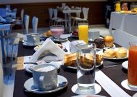 Una mesa con platos de comida y bebidas sobre ella. en Hotel UOM Buenos Aires, en Buenos Aires