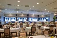 草津町にある草津温泉　大東舘の白いテーブルと椅子のあるダイニングルーム