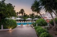 una piscina en el resort con sillas y sombrillas en Alexandra Beach, en Cos