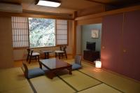 大山町にあるホテル大山　しろがねのテーブルと椅子と窓のあるリビングルーム