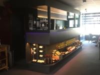 een wijnwinkel met een plank vol wijnflessen bij De Post B&B Restaurant in Klimmen