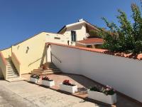 una casa blanca con macetas y escaleras en Villa Nuragica Sardegna, en Bacu Abis