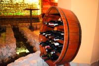 ein Holzweinregal mit vielen Weinflaschen in der Unterkunft Hotel Vila Ivanković in Buna