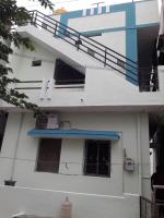 a white building with a staircase and a window at Rks Homestay in Hampi