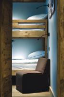 a bunk bed with a chair in a room at Chalet-Hôtel La Marmotte, La Tapiaz &amp; SPA, The Originals Relais (Hotel-Chalet de Tradition) in Les Gets